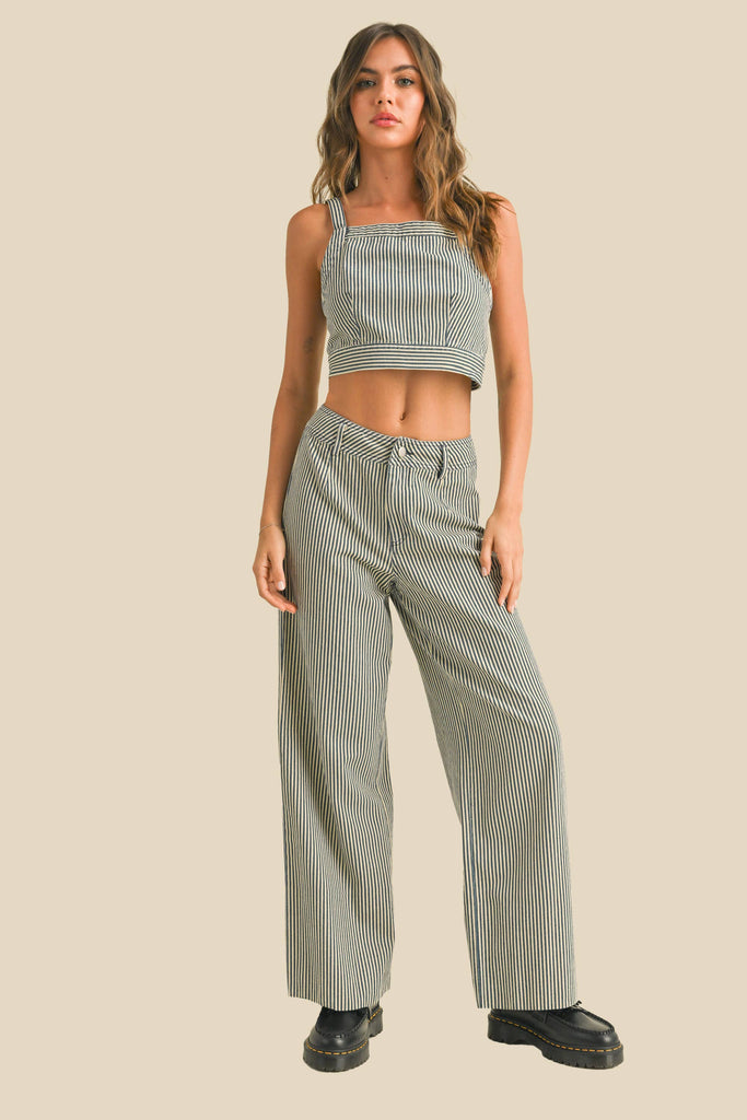 Woman wearing a sleeveless navy and white striped linen crop top with wide straps and a square neckline.