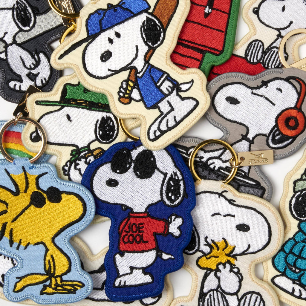 Embroidered Snoopy keychain with Snoopy lying on a colorful rainbow.