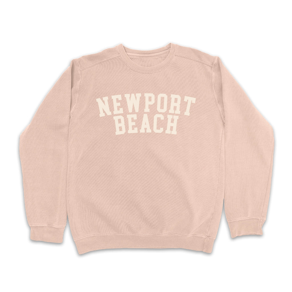 Blush pink "Newport Beach" sweatshirt with white text on a plain white background.