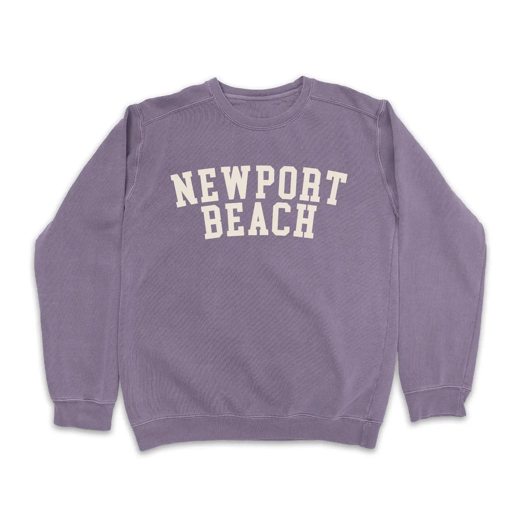 Blush pink "Newport Beach" sweatshirt with white text on a plain white background.