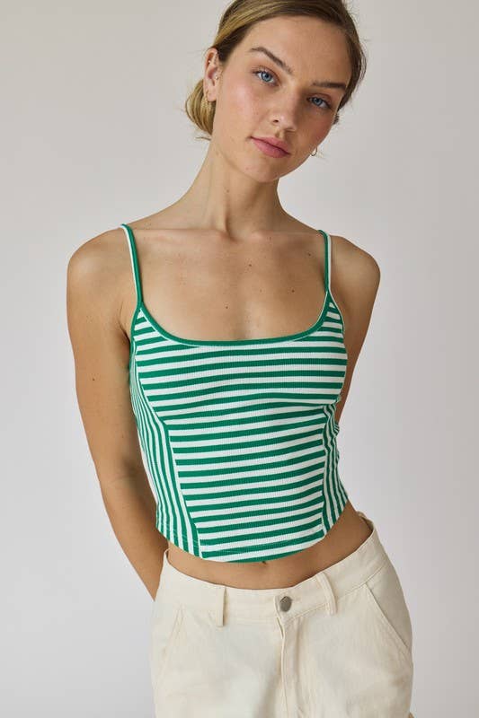 Woman wearing a green and white stripe rib knit tank top with thin straps and high-waisted beige shorts.