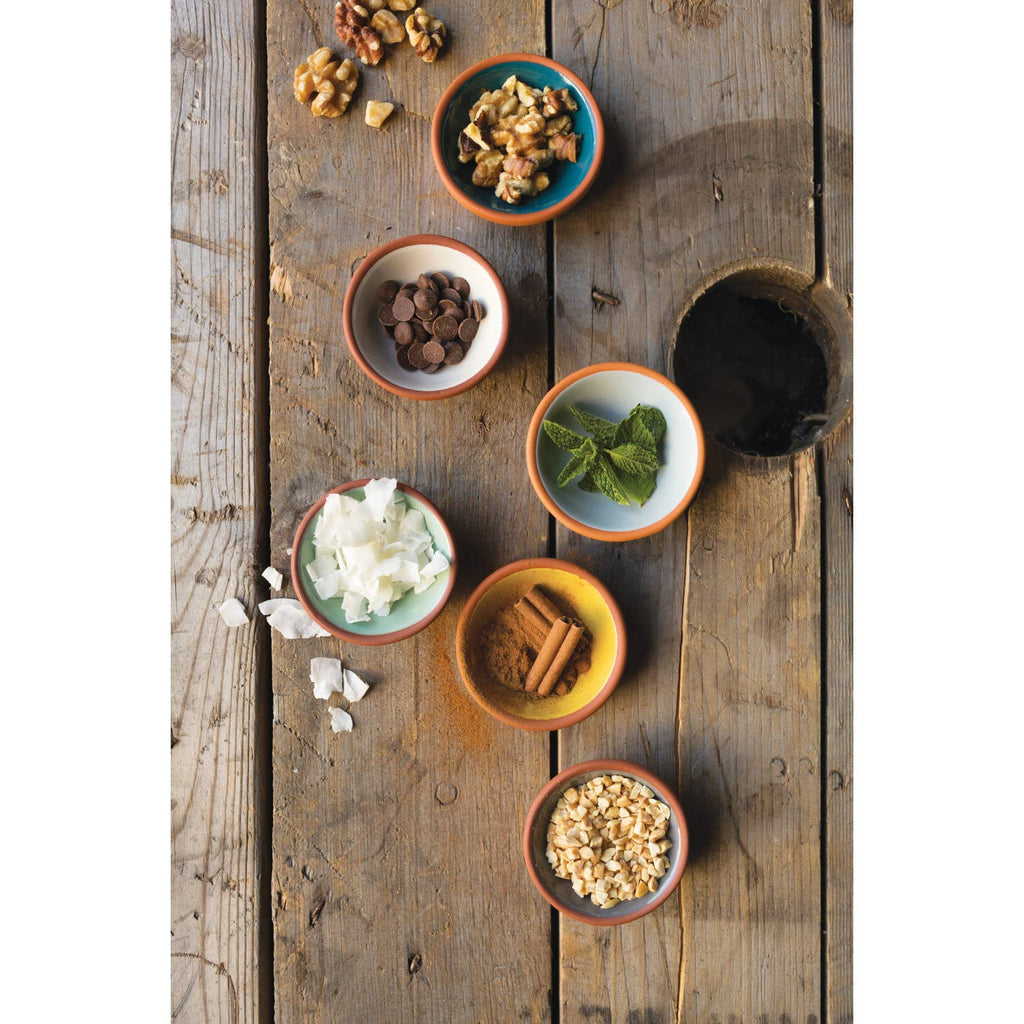 Set of six terracotta pinch bowls with contrasting glossy interiors in soft pastels and rich hues, perfect for holding spices, salt, or nuts.