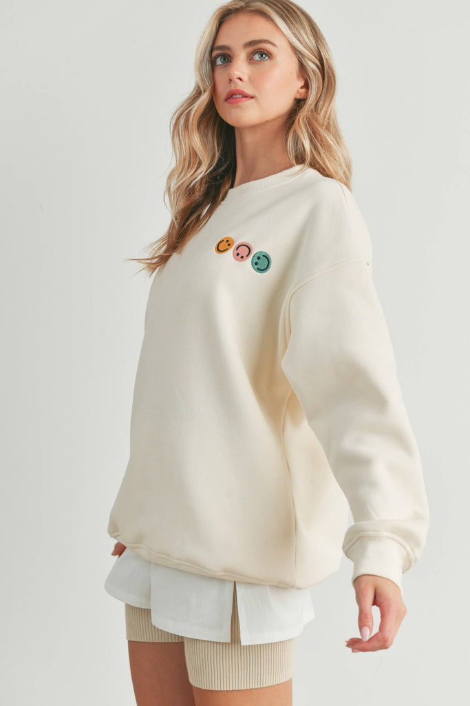 Smiley Face Embroidered Sweater with three smiley face details on the front and a larger smiley face on the back.