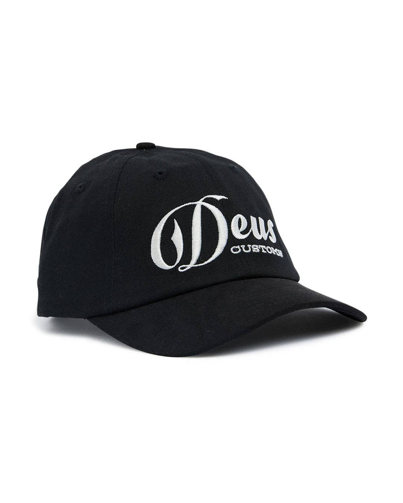 Black cap with white "Deus Customs" embroidery, curved brim, and adjustable fit.