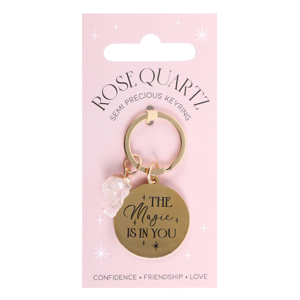 Rose quartz crystal keychain with a gold-tone charm engraved with ‘The Magic Is In You’ text.