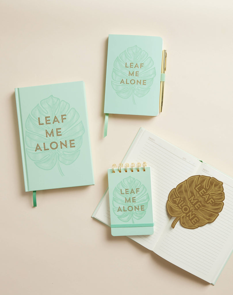 "Leaf Me Alone" brass metal bookmark in the shape of a leaf with bold text.