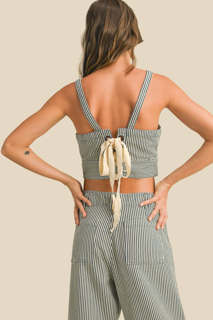 Woman wearing a sleeveless navy and white striped linen crop top with wide straps and a square neckline.