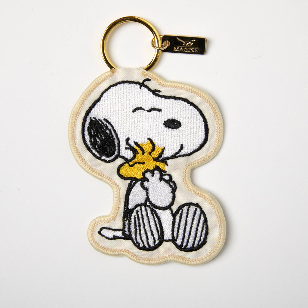 Embroidered keychain featuring a cute embrace, designed with high-quality stitching and a gold-toned keyring for a stylish touch.