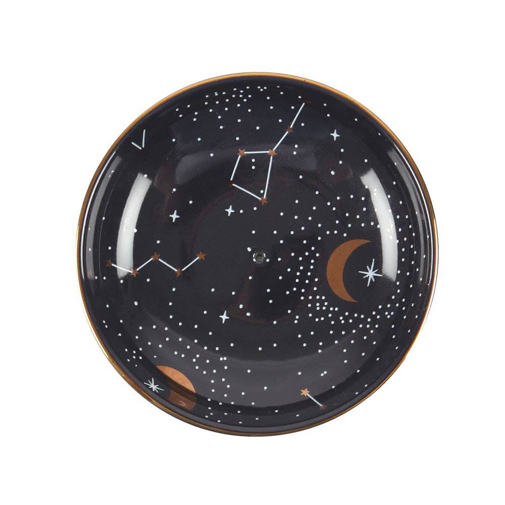 A celestial-themed ceramic dish with a constellation design, golden moons, and stars, used as an incense holder or jewelry tray.