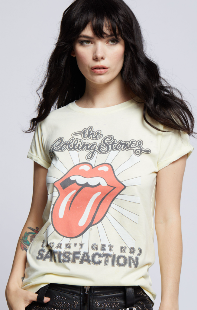 Woman wearing a vintage-style yellow Rolling Stones graphic t-shirt with the iconic tongue-and-lips logo and "Can't Get No Satisfaction" text.