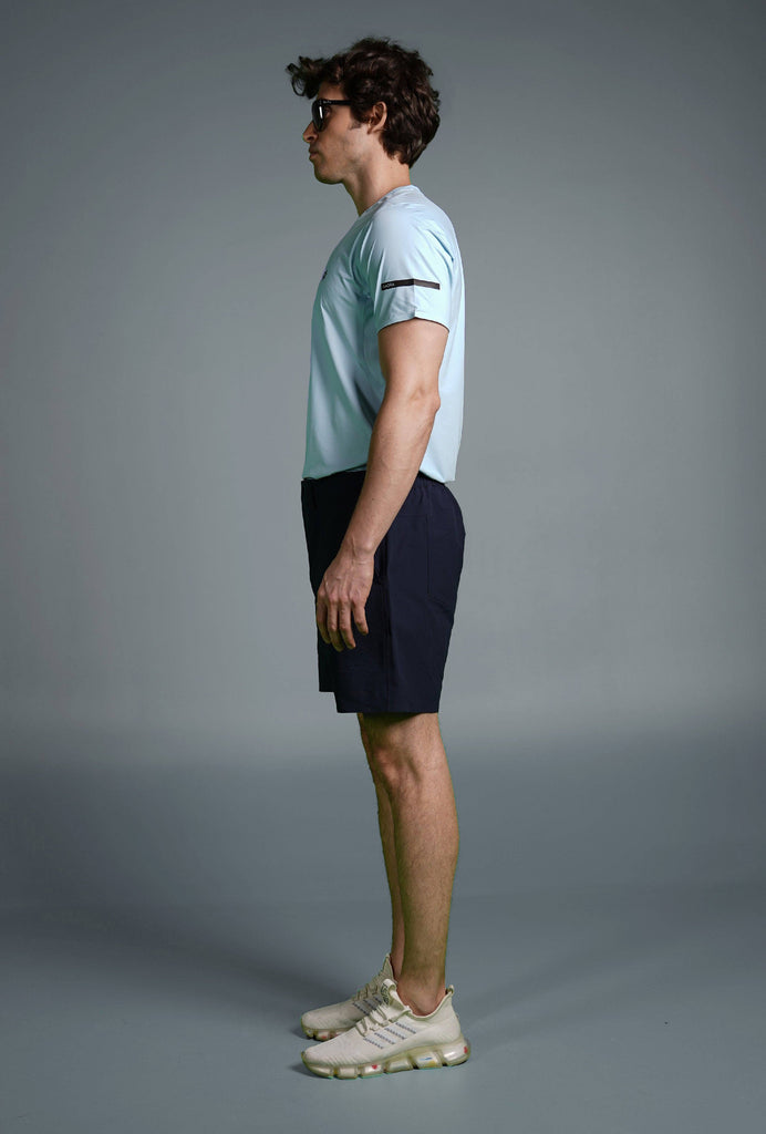 Man wearing Voyager Shorts and a light blue t-shirt, showcasing a comfortable and stylish casual look.