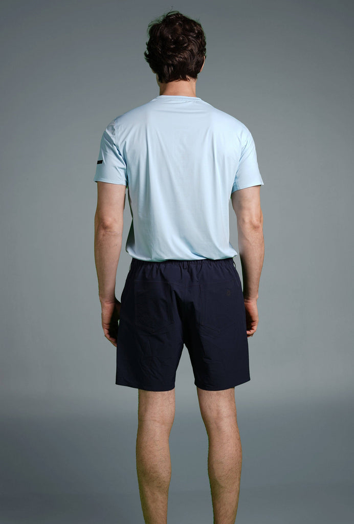 Man wearing Voyager Shorts and a light blue t-shirt, showcasing a comfortable and stylish casual look.