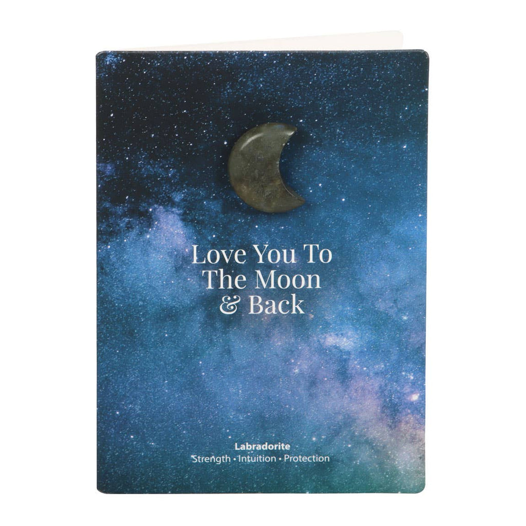 Hand holding a greeting card with a small labradorite crystal crescent moon and ‘Love You To The Moon & Back’ text.