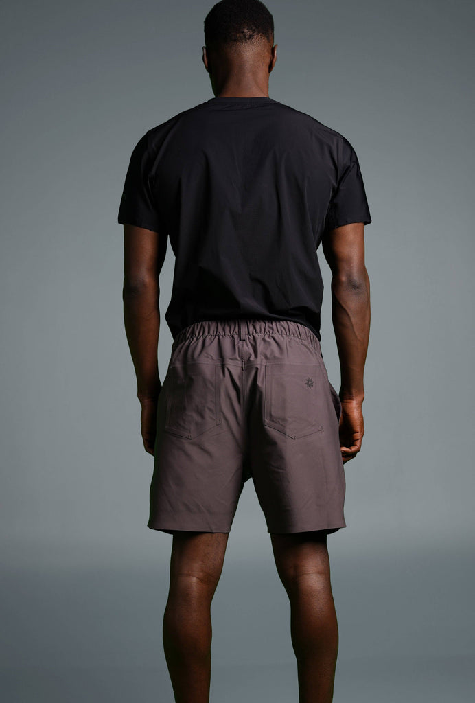 Man wearing Voyager Shorts and a light blue t-shirt, showcasing a comfortable and stylish casual look.