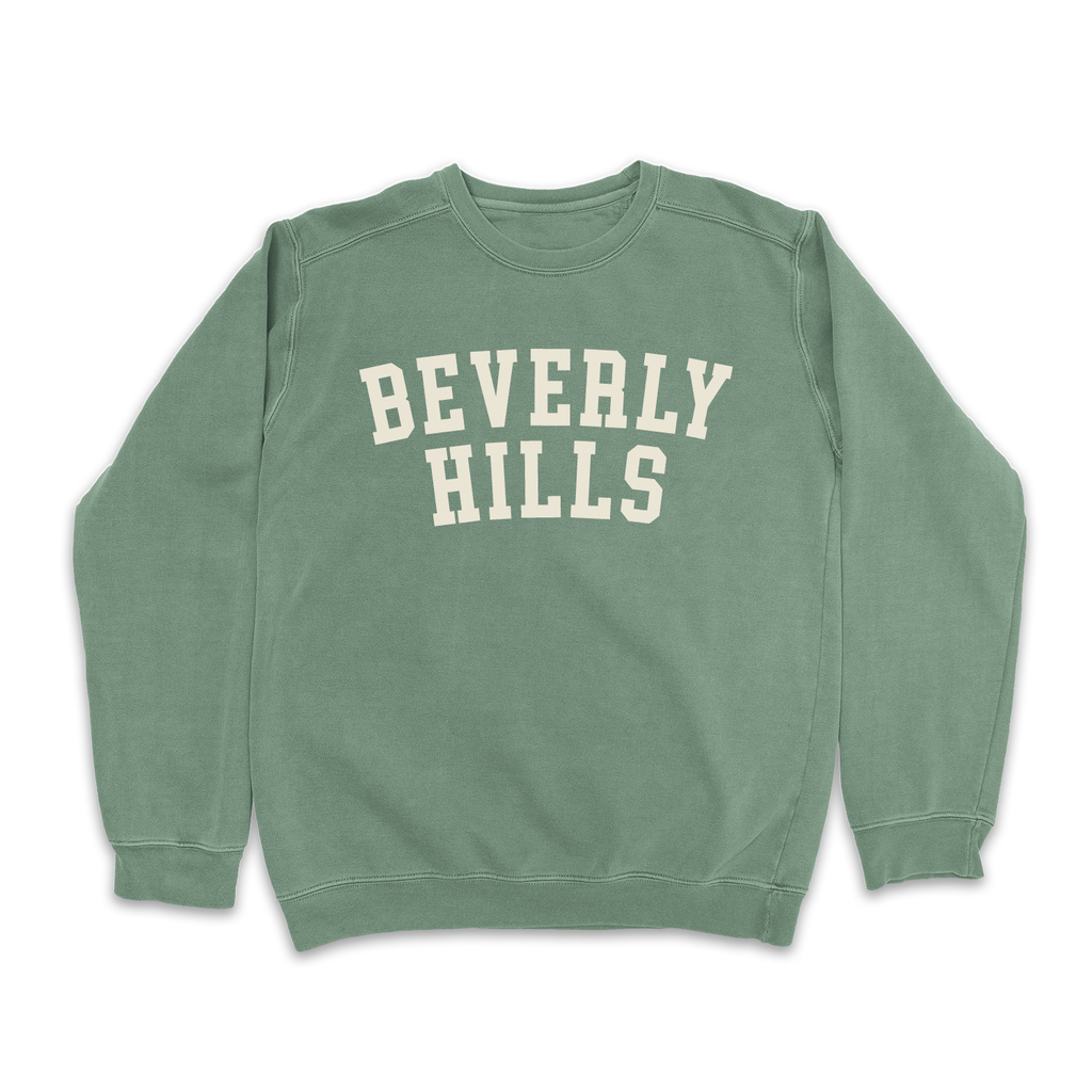 Sage green sweatshirt with "Beverly Hills" lettering on a sunny palm tree background.