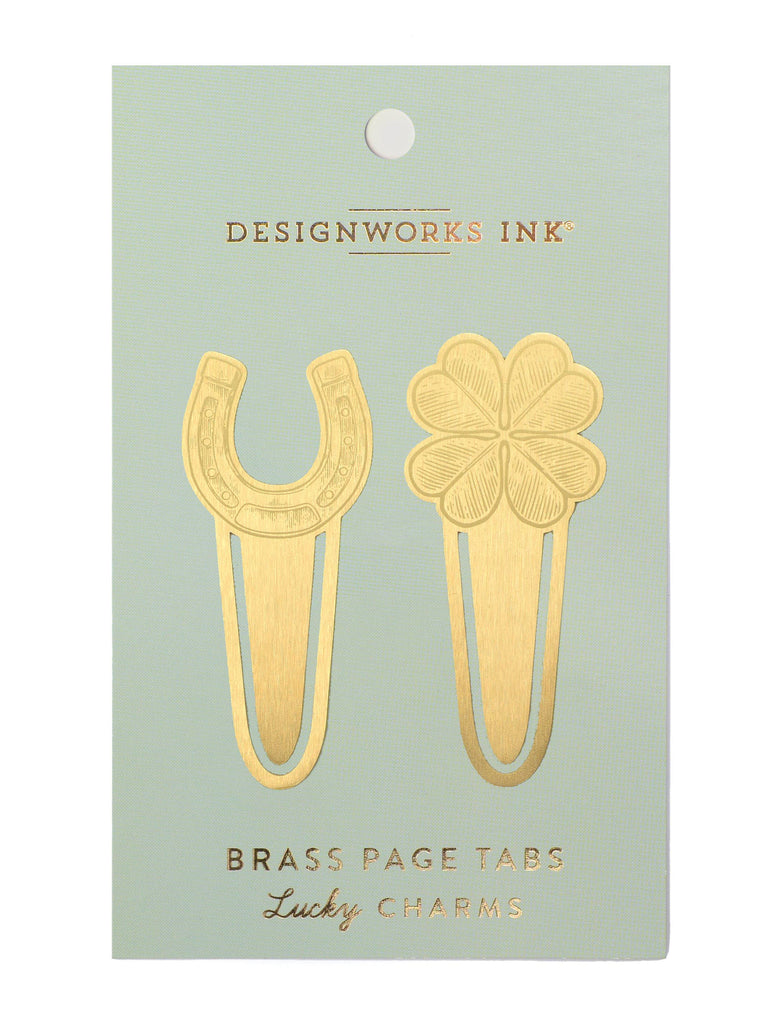A set of two brass page tabs in the shape of a horseshoe and a four-leaf clover, displayed on a pastel green backing card.