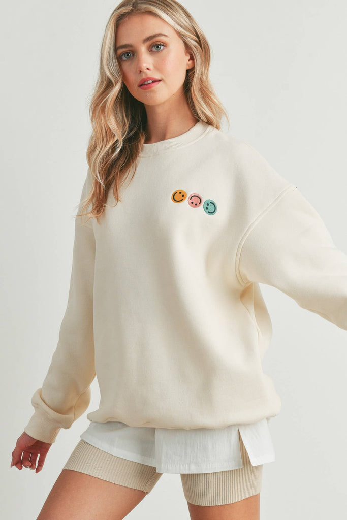 Smiley Face Embroidered Sweater with three smiley face details on the front and a larger smiley face on the back.