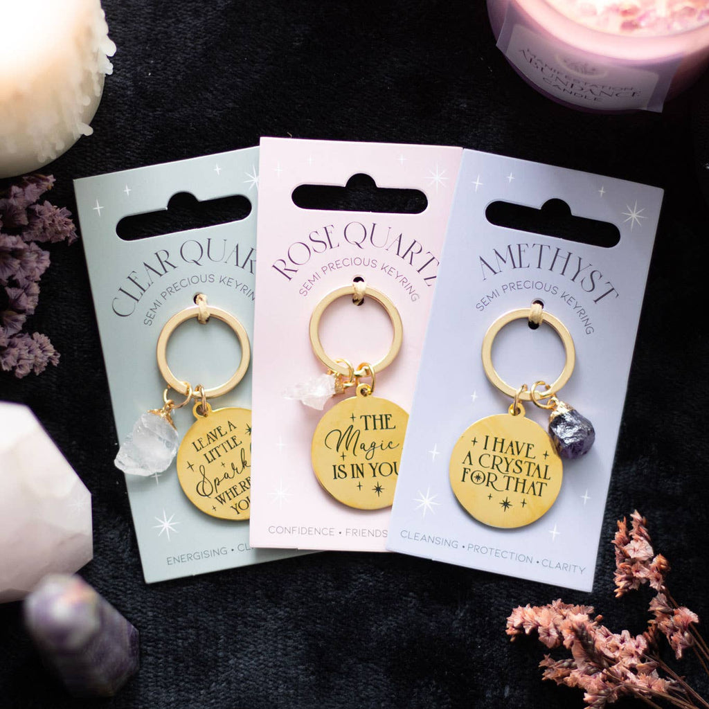 Rose quartz crystal keychain with a gold-tone charm engraved with ‘The Magic Is In You’ text.