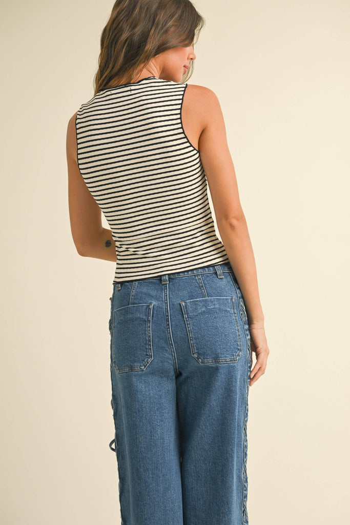 Striped knit tank top with a scoop neckline and ruched bust, styled with high-waisted denim for a casual yet chic look.