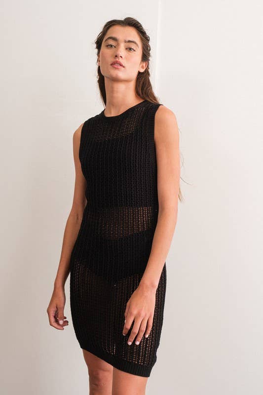 Woman wearing a sleeveless black crochet mini dress.