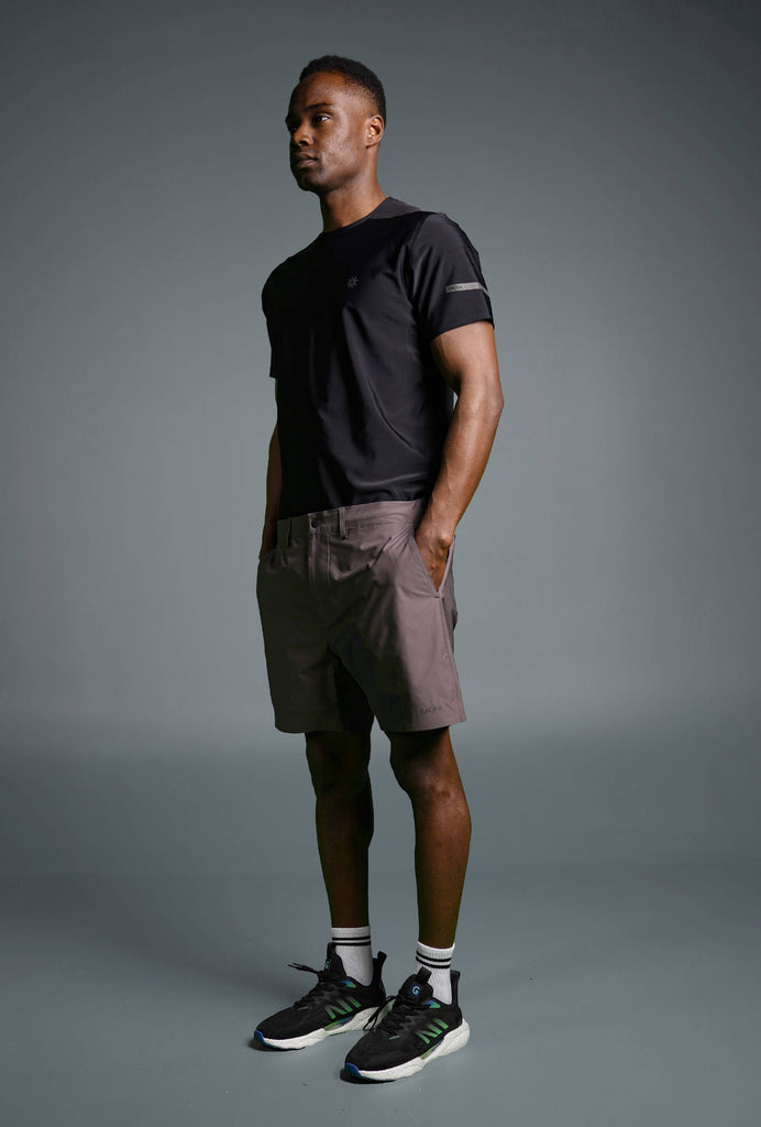 Man wearing Voyager Shorts and a light blue t-shirt, showcasing a comfortable and stylish casual look.