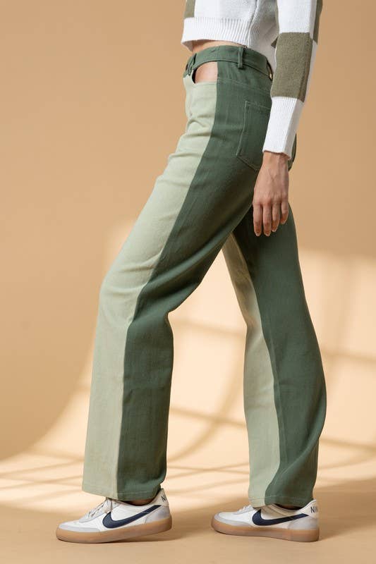 Woman wearing high waist color block pants with cutout details.