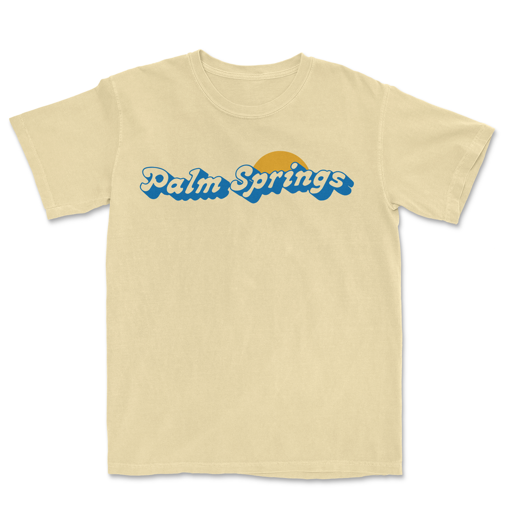 Yellow "Palm Springs" T-shirt with blue text and a sun graphic on a white background.