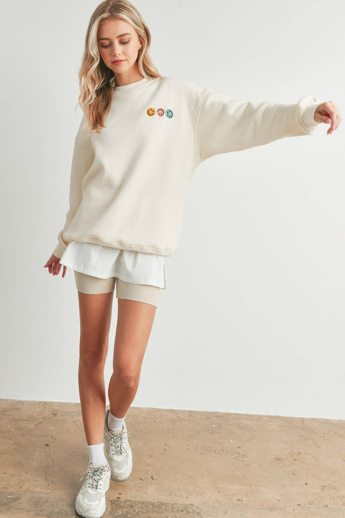 Smiley Face Embroidered Sweater with three smiley face details on the front and a larger smiley face on the back.