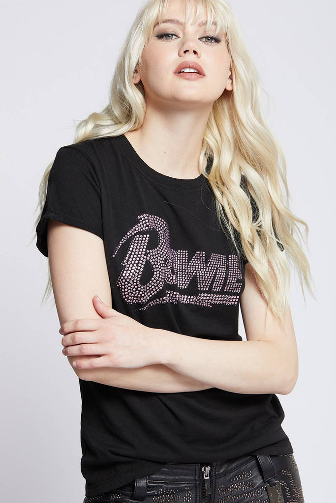 Young woman wearing a black David Bowie graphic t-shirt with rhinestone detailing, paired with studded black pants for a chic, rock-inspired style.