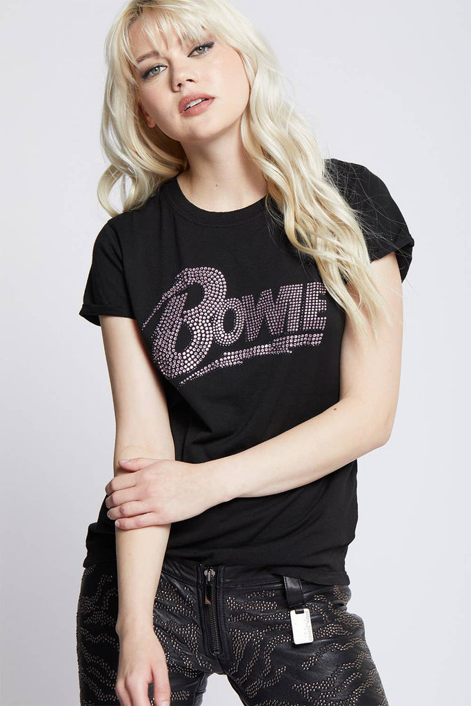 Young woman wearing a black David Bowie graphic t-shirt with rhinestone detailing, paired with studded black pants for a chic, rock-inspired style.