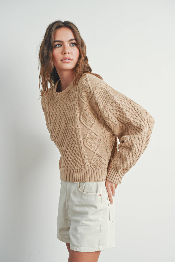 Sandridge Cable Knit Sweater with intricate cable detailing, relaxed fit, and warm beige hue, perfect for layering in any season.