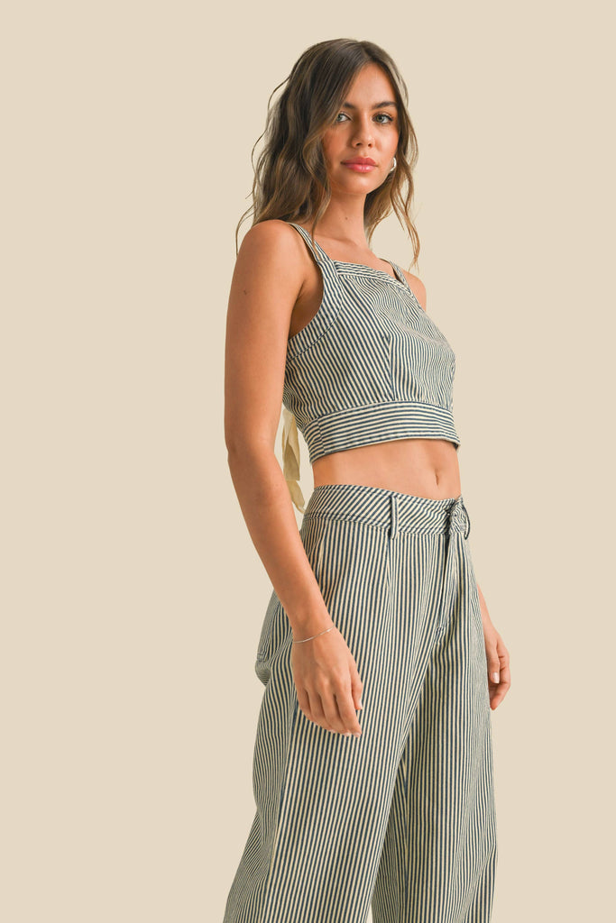 Woman wearing a sleeveless navy and white striped linen crop top with wide straps and a square neckline.