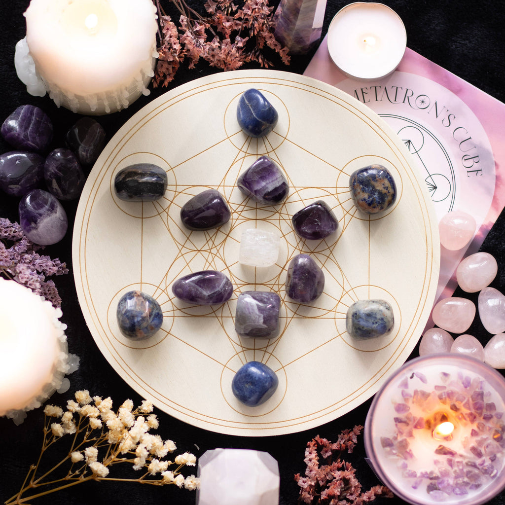 Metatron’s Cube Crystal Grid Set with Sodalite and Amethyst Tumblestones on an Engraved Wooden Grid, surrounded by candles and other crystals.