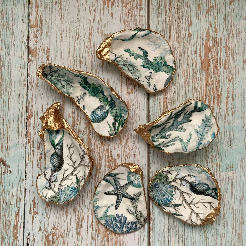 Decorative shells featuring intricate marine designs with gold edges, ideal for adding a touch of oceanic beauty to your home decor.